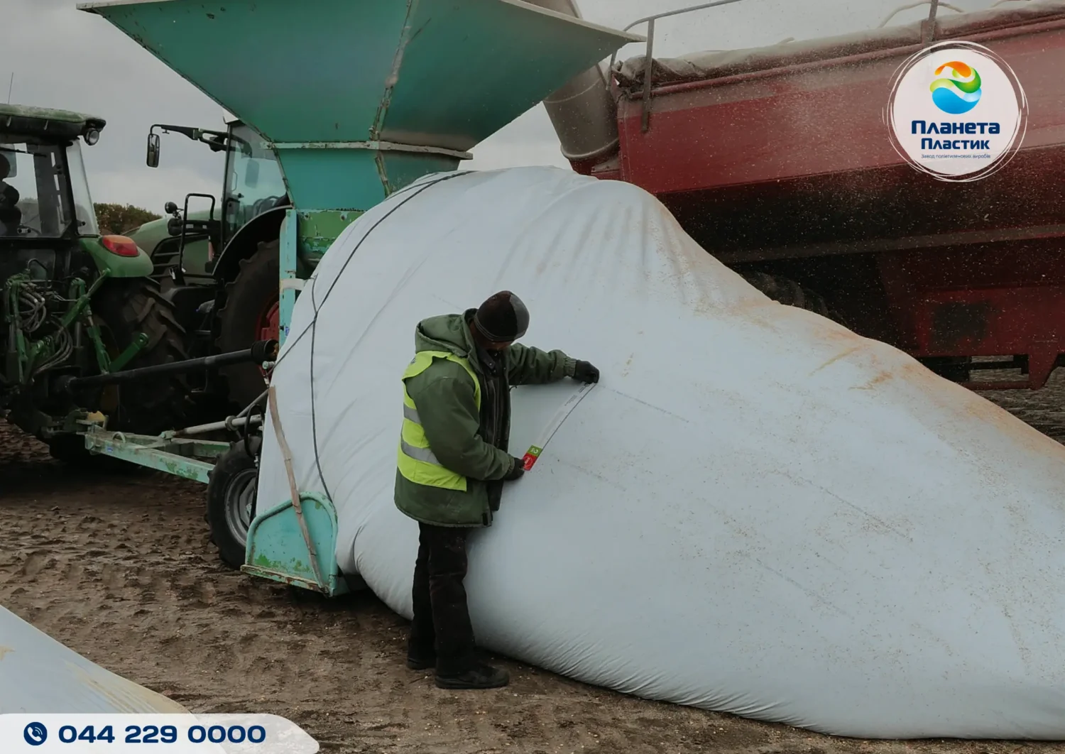 Работник проверяет уровень растяжения полимерного рукава Harwell с помощью специальной линейки во время загрузки зерна.